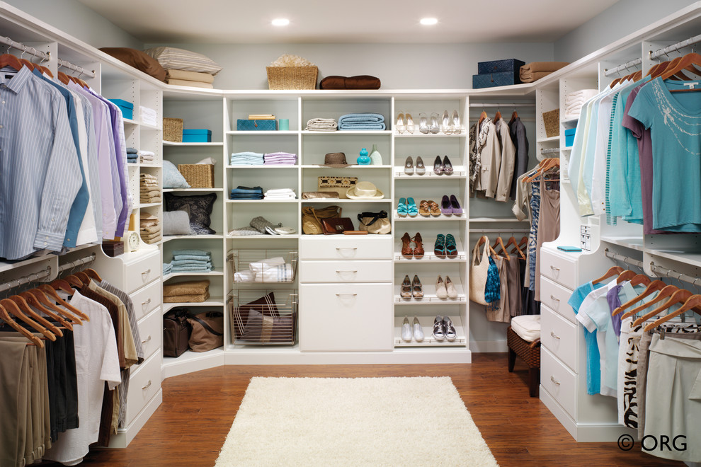 Foto de vestidor unisex minimalista grande con armarios abiertos, puertas de armario blancas y suelo de madera en tonos medios