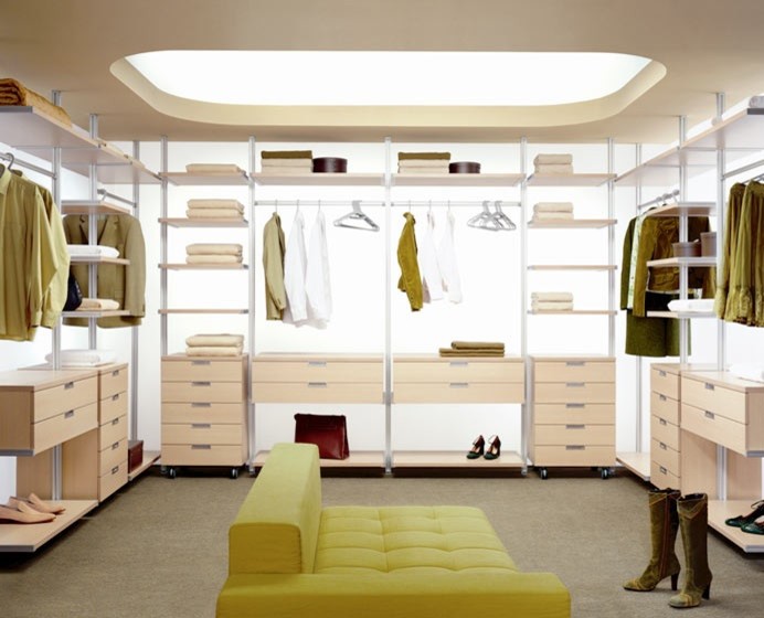 Immagine di un grande spazio per vestirsi unisex moderno con ante lisce, ante in legno chiaro e moquette