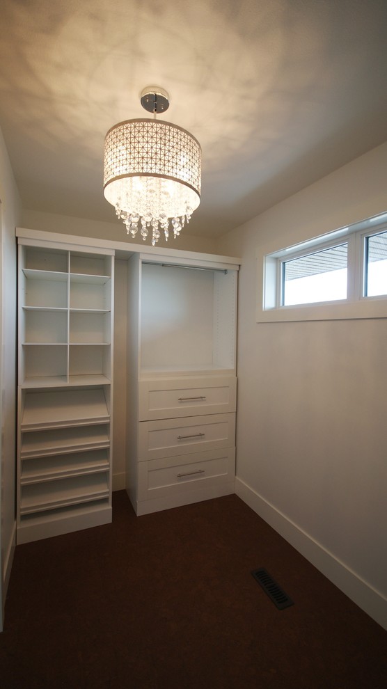 Photo of a medium sized contemporary gender neutral walk-in wardrobe in Calgary with recessed-panel cabinets, white cabinets and cork flooring.