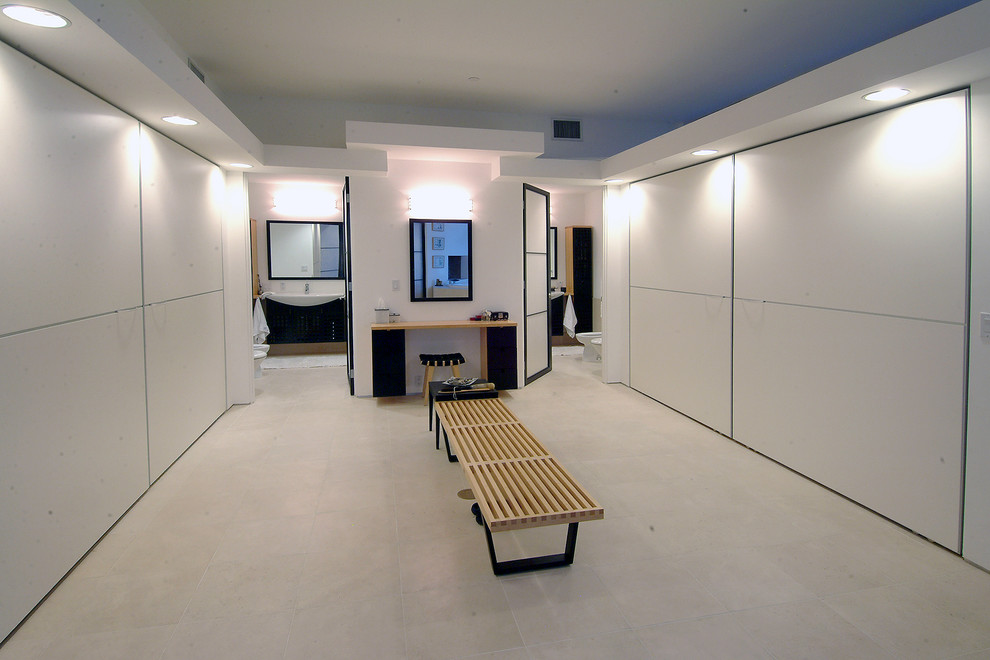 Inspiration pour un dressing room minimaliste avec un placard à porte plane et des portes de placard blanches.