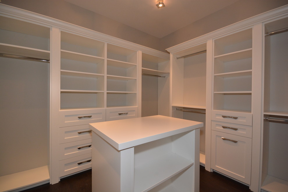 Cette photo montre un dressing room tendance de taille moyenne et neutre avec un placard à porte shaker, des portes de placard blanches et parquet foncé.