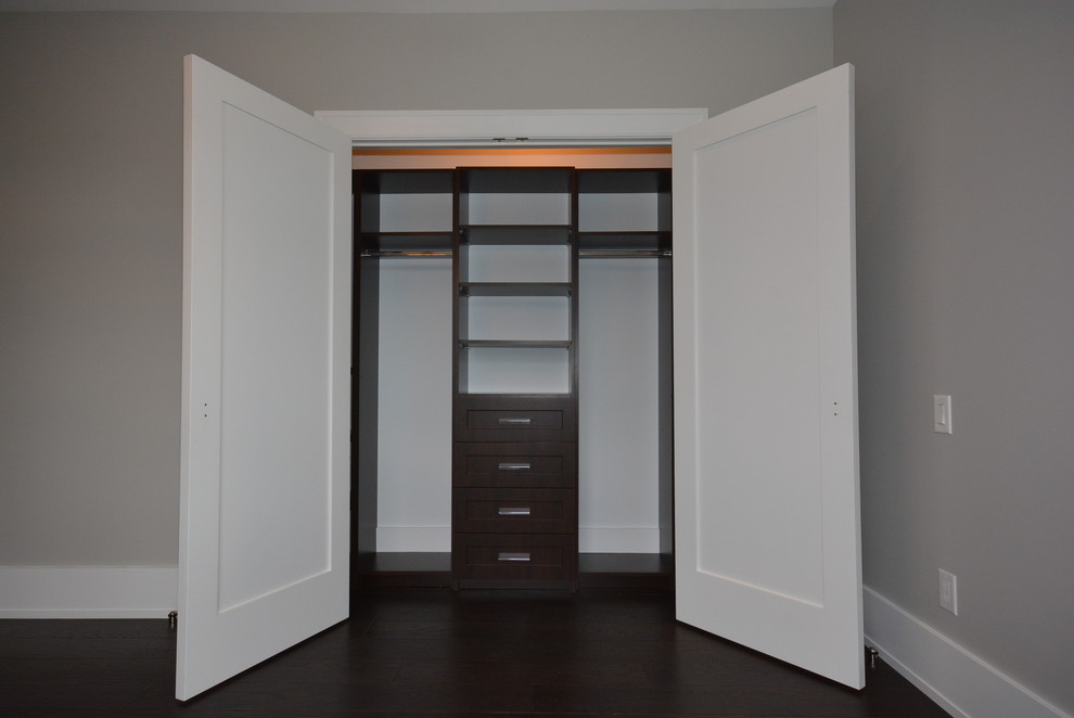 Foto de armario unisex contemporáneo pequeño con armarios estilo shaker, puertas de armario de madera en tonos medios y suelo de madera oscura