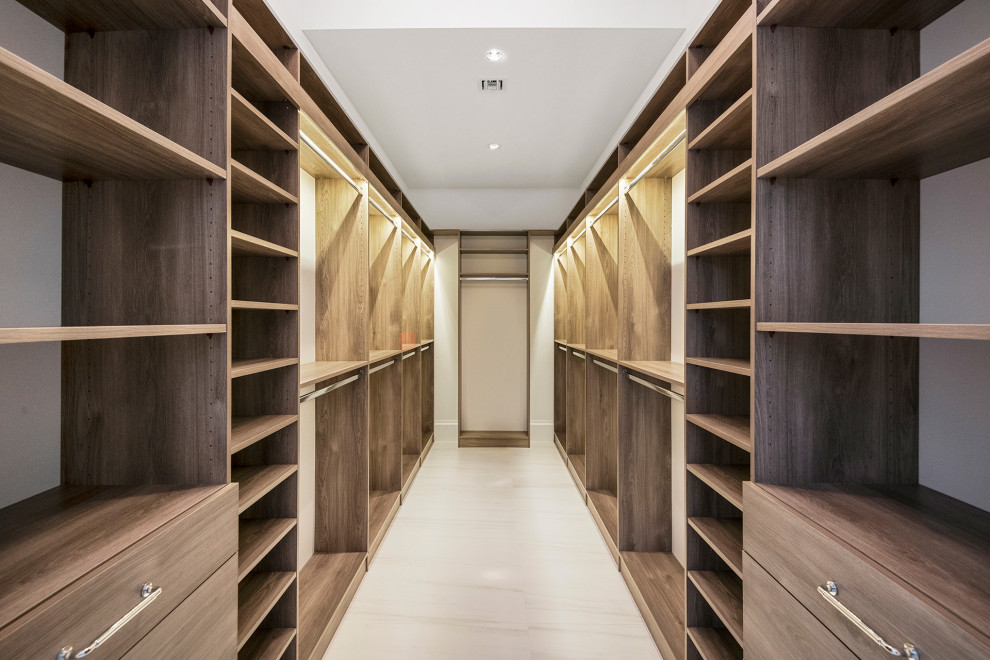 Ejemplo de armario vestidor unisex tradicional renovado grande con armarios con paneles lisos, puertas de armario de madera oscura, suelo laminado y suelo blanco