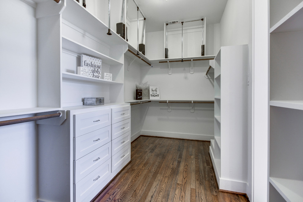 Ejemplo de armario vestidor unisex tradicional renovado grande con armarios estilo shaker, puertas de armario blancas, suelo de madera en tonos medios y suelo marrón