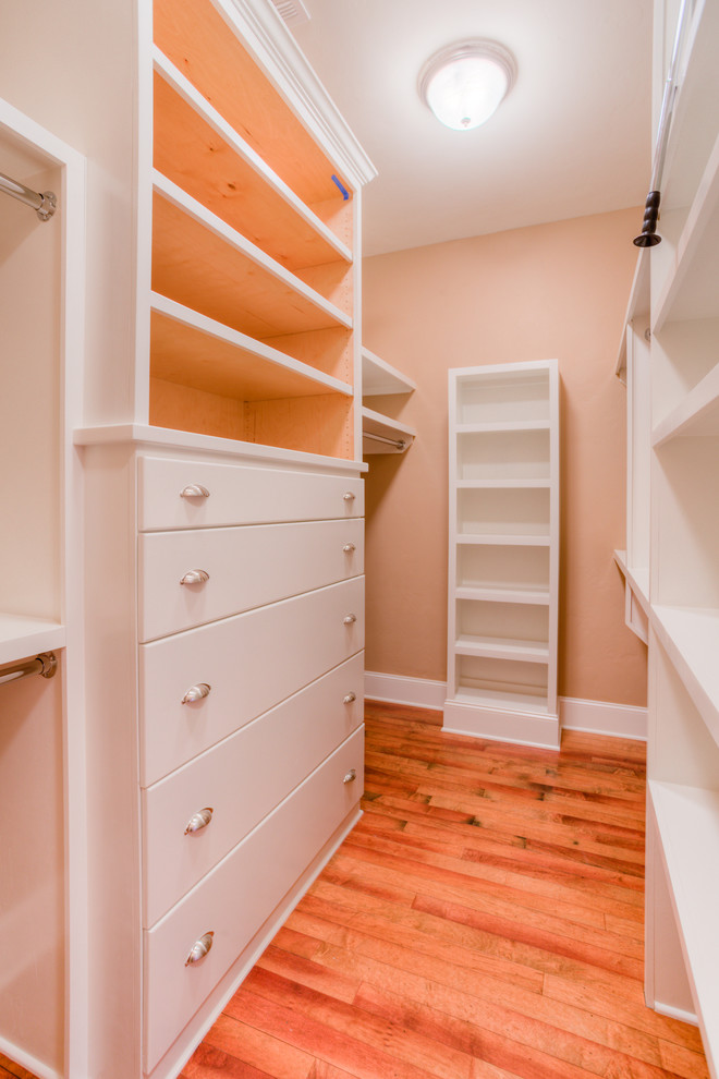 This is an example of a large traditional walk-in wardrobe for men in Austin with flat-panel cabinets and white cabinets.