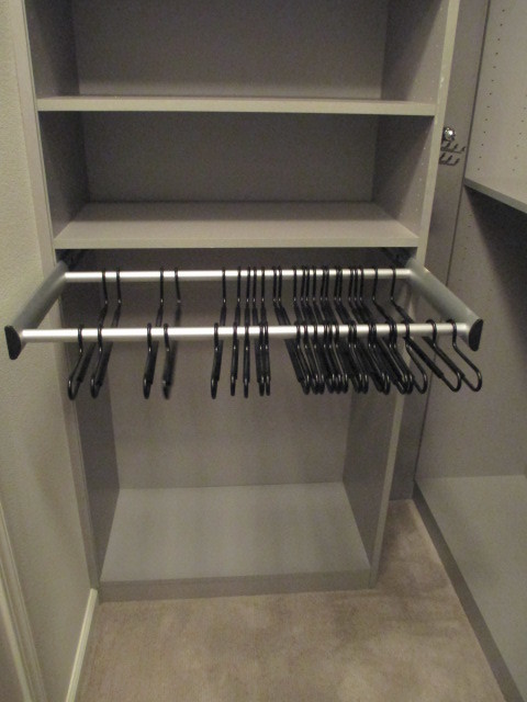 Small minimalist gender-neutral carpeted and beige floor walk-in closet photo in Los Angeles with flat-panel cabinets and gray cabinets