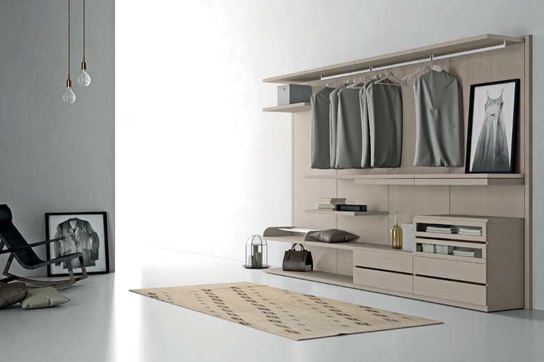 Ejemplo de armario vestidor unisex minimalista de tamaño medio con puertas de armario de madera oscura y suelo de cemento