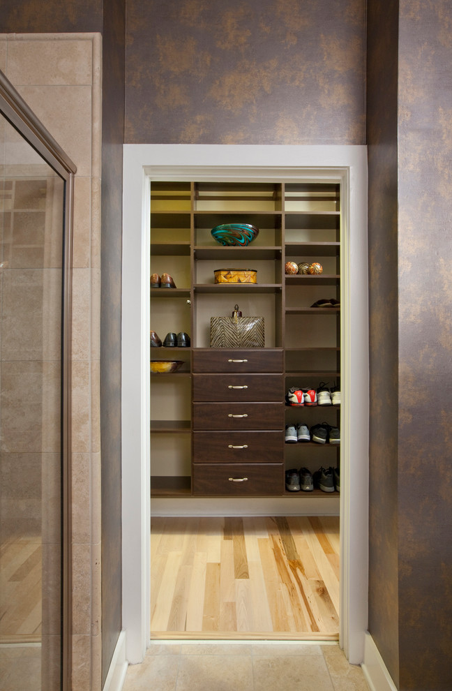 Esempio di una cabina armadio per uomo minimalista di medie dimensioni con ante lisce, ante in legno bruno e parquet chiaro