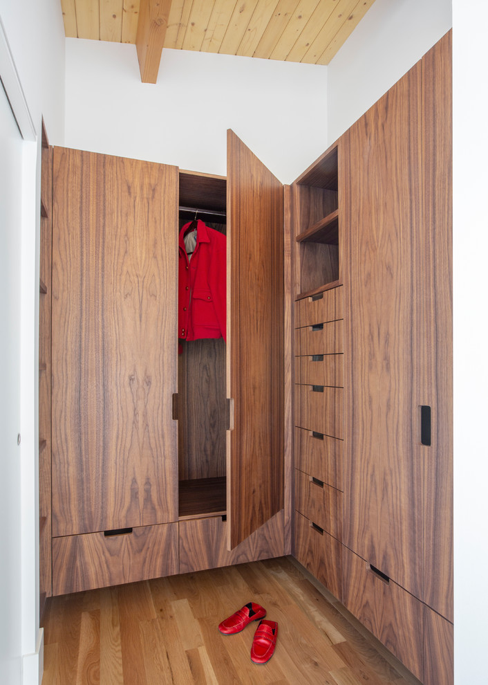 Esempio di una piccola cabina armadio unisex minimalista con ante lisce, ante in legno bruno, parquet chiaro e pavimento marrone