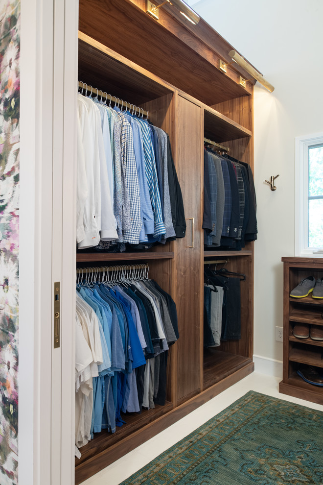 This is an example of a classic walk-in wardrobe in Kansas City with flat-panel cabinets, dark wood cabinets and white floors.