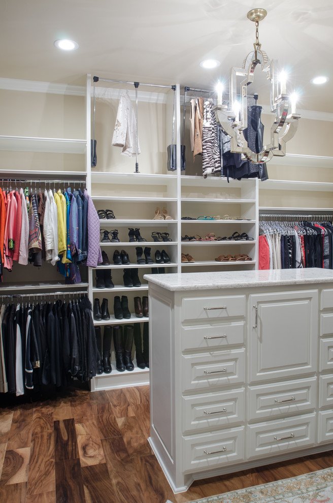 Photo of a large mediterranean gender neutral walk-in wardrobe in Austin with open cabinets, white cabinets, dark hardwood flooring and brown floors.