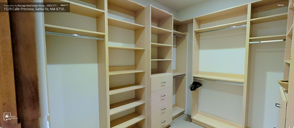 Idee per una cabina armadio unisex minimalista di medie dimensioni con ante lisce e ante in legno chiaro