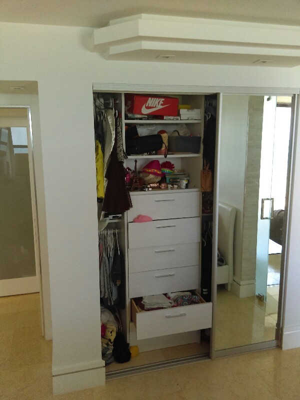 This is an example of a medium sized modern wardrobe in Miami.