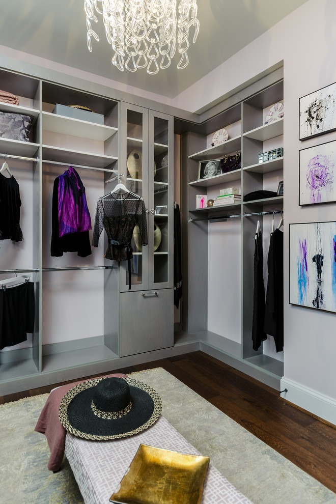 This is an example of a medium sized modern walk-in wardrobe for women in Los Angeles with flat-panel cabinets, grey cabinets and medium hardwood flooring.