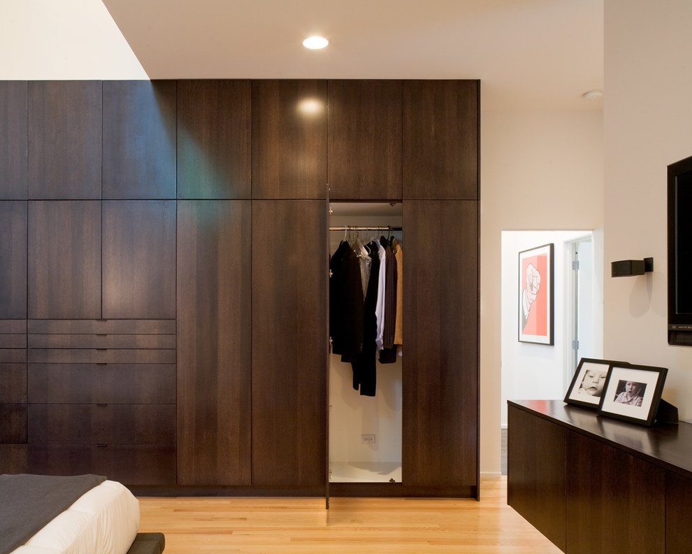 Reach-in closet - modern reach-in closet idea in Kansas City with flat-panel cabinets and dark wood cabinets