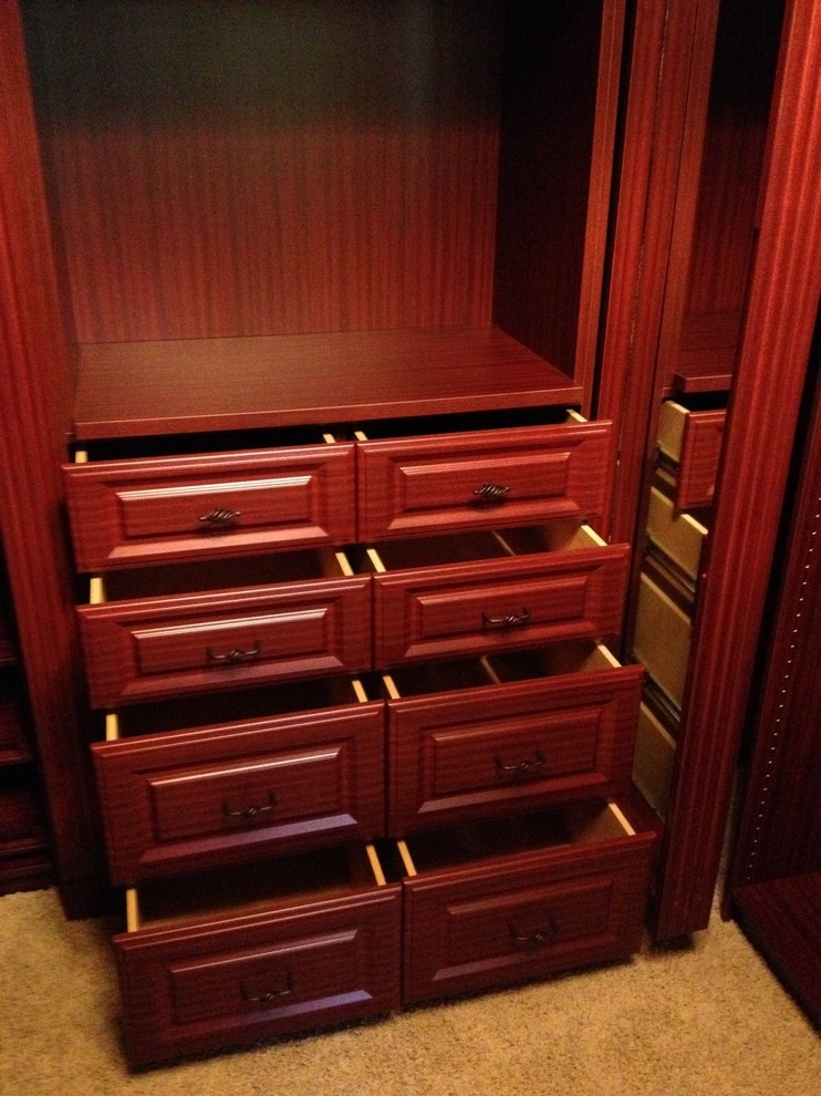 Ejemplo de armario vestidor unisex tradicional de tamaño medio con armarios con paneles con relieve, puertas de armario marrones, moqueta y suelo beige