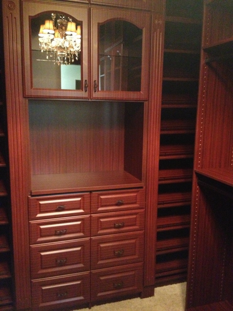 Exempel på ett mellanstort klassiskt walk-in-closet för könsneutrala, med luckor med upphöjd panel, bruna skåp, heltäckningsmatta och beiget golv