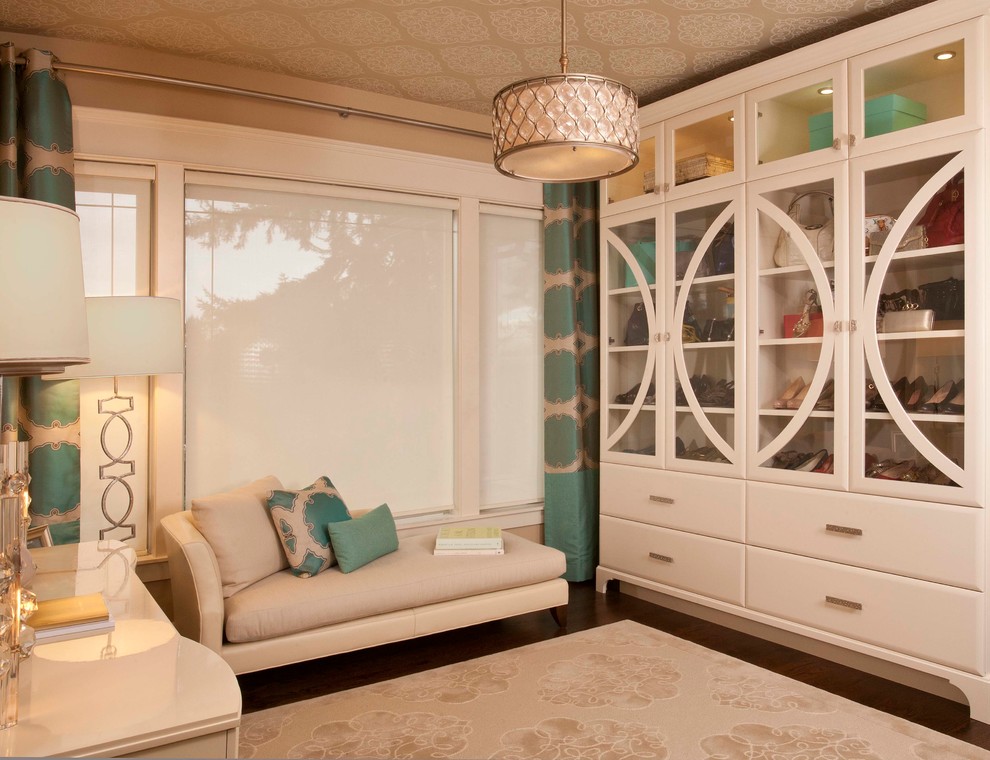 Imagen de armario y vestidor clásico renovado de tamaño medio con armarios tipo vitrina, puertas de armario blancas y suelo de madera oscura
