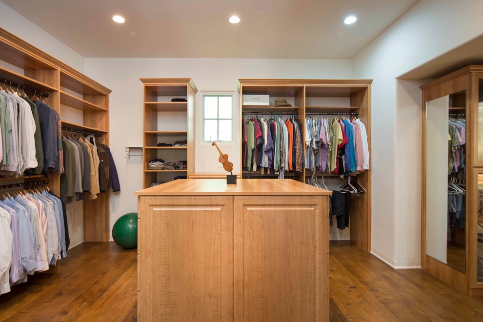 Inspiration for a large mediterranean gender neutral walk-in wardrobe in Santa Barbara with raised-panel cabinets, light wood cabinets and medium hardwood flooring.