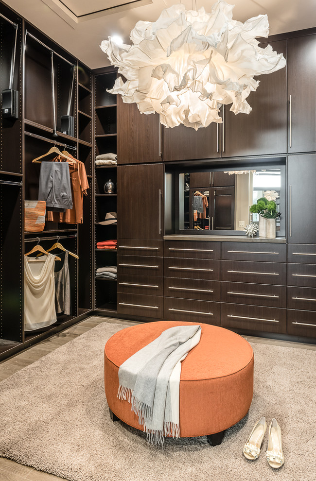 Imagen de vestidor unisex actual grande con armarios con paneles lisos, puertas de armario de madera en tonos medios y suelo de baldosas de porcelana