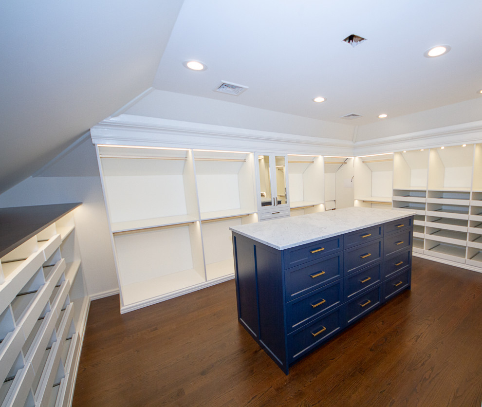 Inspiration for a large traditional gender neutral walk-in wardrobe in New York with recessed-panel cabinets, blue cabinets and dark hardwood flooring.