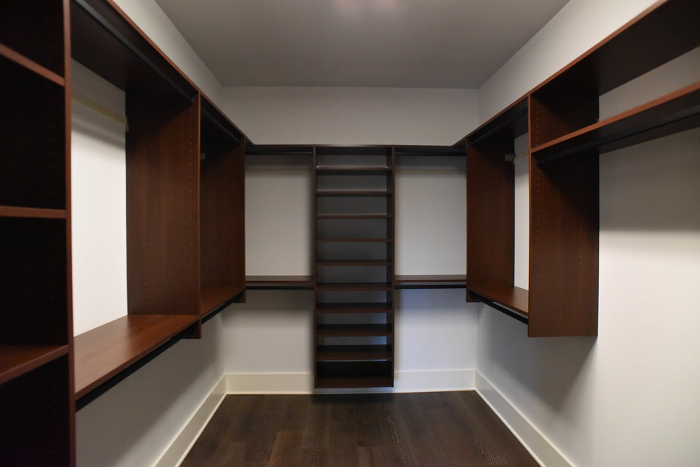 Foto de armario vestidor unisex tradicional de tamaño medio con armarios abiertos, puertas de armario de madera en tonos medios y suelo de madera oscura