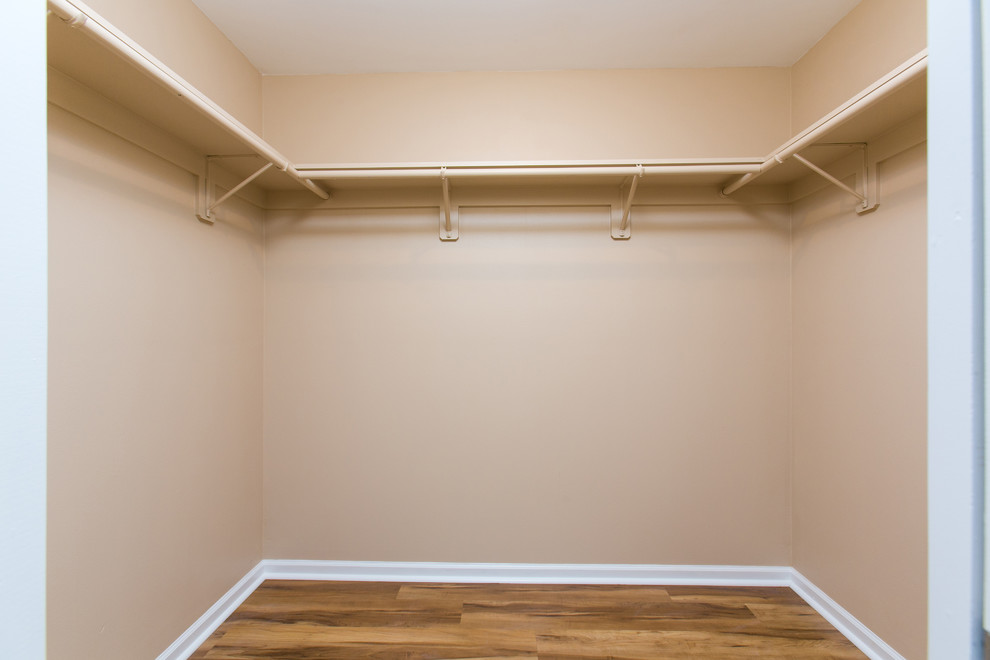 Foto de armario vestidor unisex clásico renovado pequeño con suelo de madera en tonos medios y suelo marrón