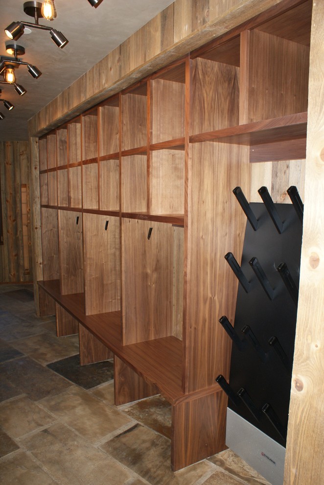 Immagine di un grande spazio per vestirsi unisex tradizionale con ante in legno scuro, nessun'anta e pavimento in ardesia