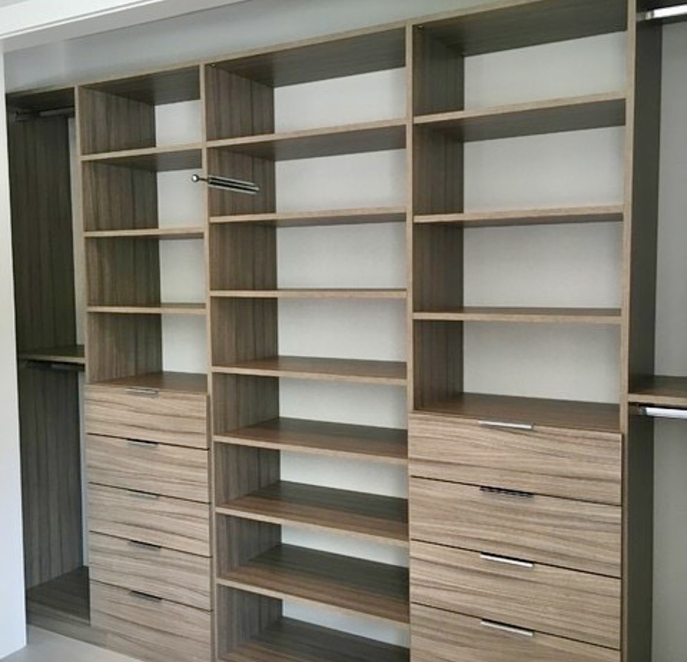 Ejemplo de armario de hombre minimalista de tamaño medio con armarios con paneles lisos, puertas de armario de madera oscura y suelo de baldosas de porcelana