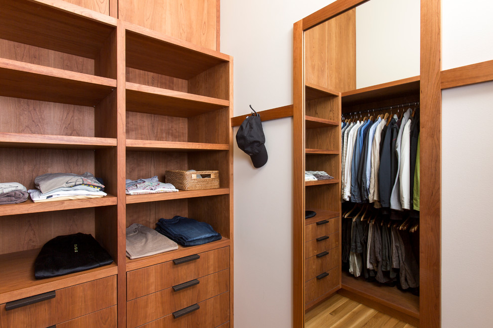 Large contemporary walk-in wardrobe for men in Portland with flat-panel cabinets, medium wood cabinets and light hardwood flooring.