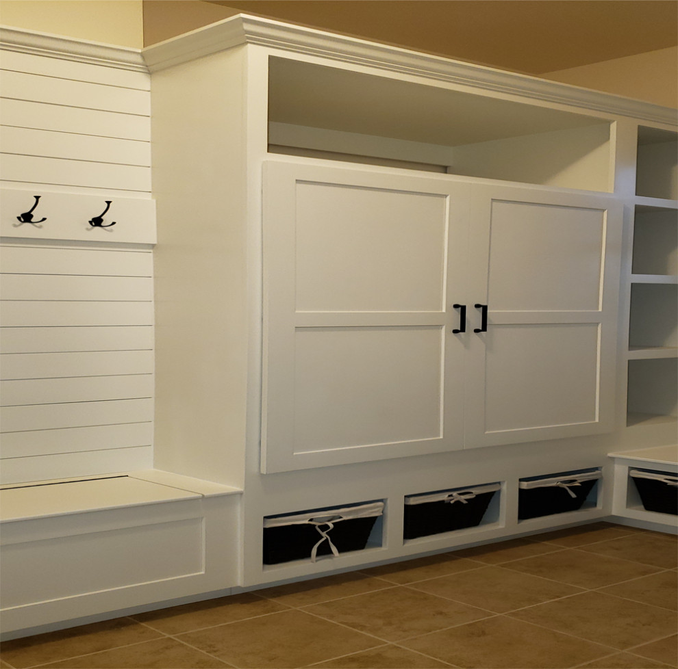Diseño de armario y vestidor unisex de estilo americano grande con armarios estilo shaker, puertas de armario blancas, suelo de baldosas de cerámica y suelo beige