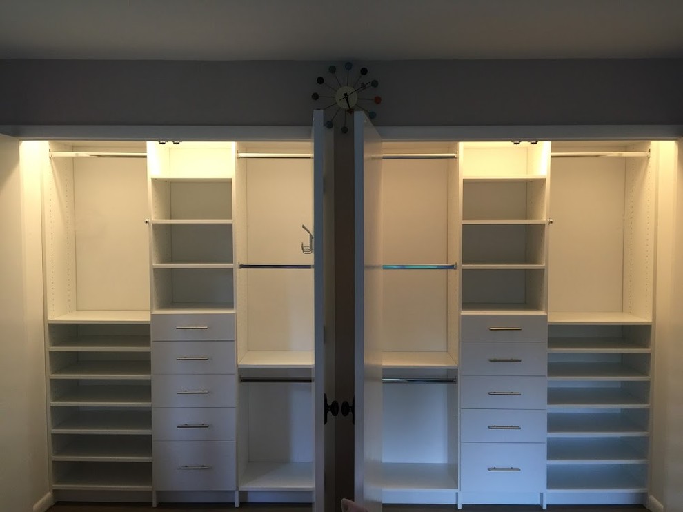 Idee per un armadio o armadio a muro unisex minimalista di medie dimensioni con ante lisce, ante bianche e parquet scuro