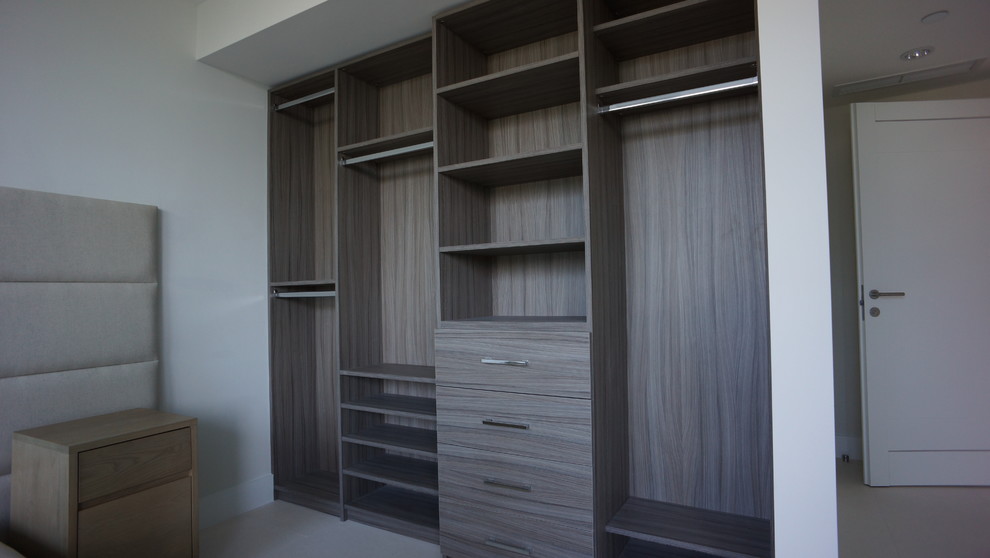 Exemple d'un grand dressing room tendance en bois foncé avec un placard à porte plane.