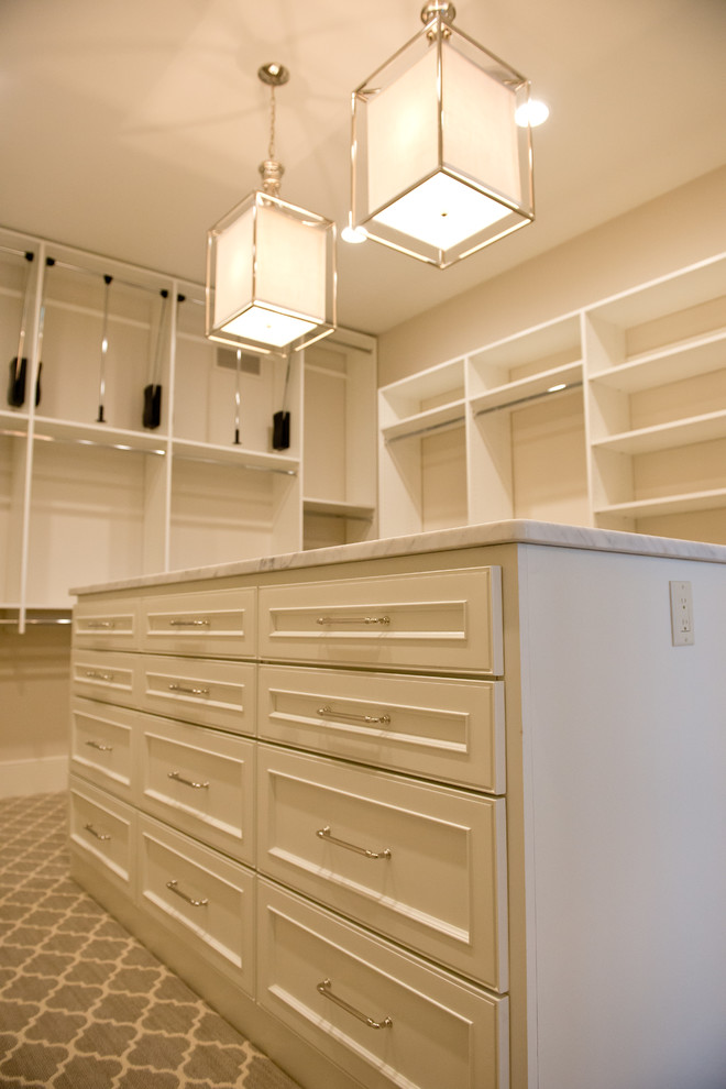 Diseño de vestidor unisex campestre grande con armarios con paneles empotrados, puertas de armario blancas, moqueta y suelo gris