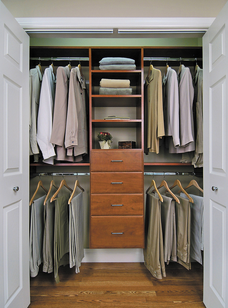 Foto de armario unisex contemporáneo pequeño con armarios con paneles lisos, puertas de armario de madera oscura y suelo de madera en tonos medios