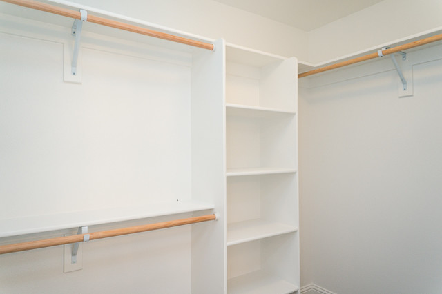 Walk-in closet - mid-sized craftsman carpeted walk-in closet idea in Portland with open cabinets and white cabinets