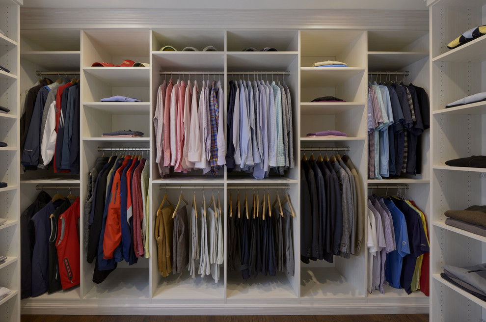 Example of a large trendy gender-neutral dark wood floor walk-in closet design in New York with white cabinets