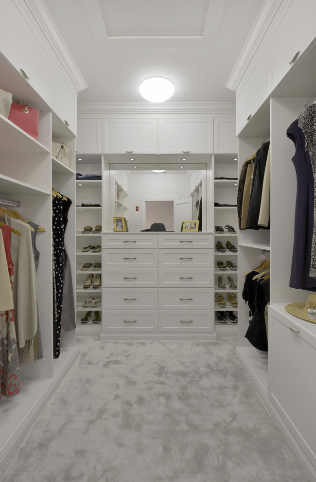 Пример оригинального дизайна: большая гардеробная комната унисекс в современном стиле с фасадами в стиле шейкер, белыми фасадами и ковровым покрытием