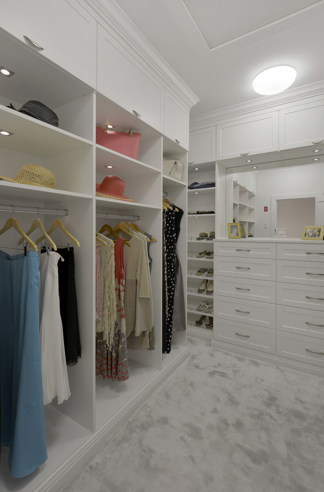 Пример оригинального дизайна: большая гардеробная комната унисекс в современном стиле с фасадами в стиле шейкер, белыми фасадами и ковровым покрытием