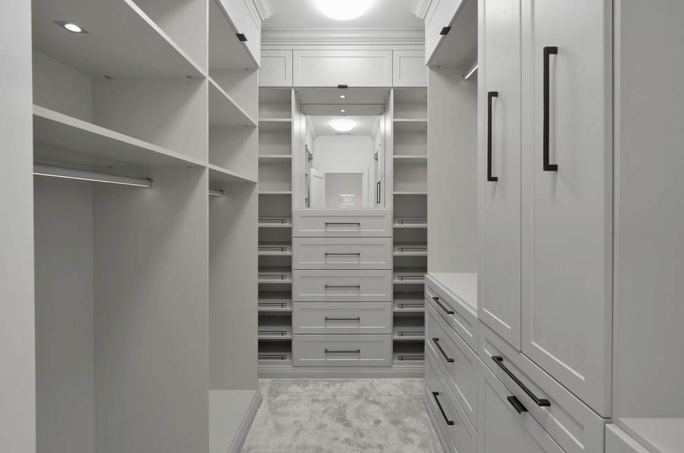 Large trendy gender-neutral carpeted walk-in closet photo in New York with shaker cabinets and white cabinets