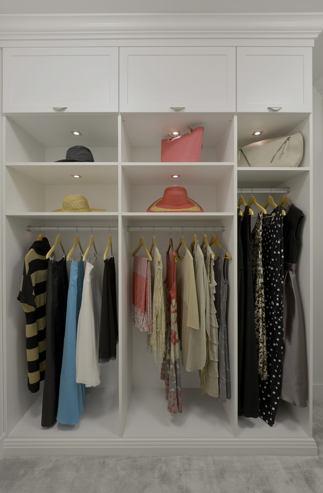 Example of a large trendy gender-neutral carpeted walk-in closet design in New York with shaker cabinets and white cabinets