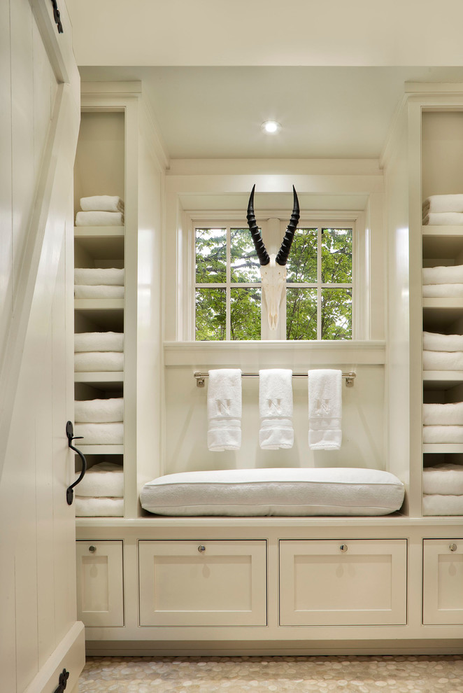 Inspiration for a large timeless gender-neutral dressing room remodel in New York with recessed-panel cabinets and white cabinets
