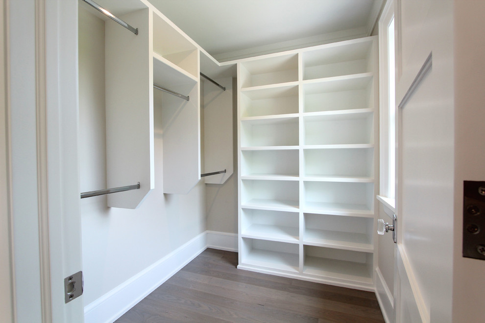 Exempel på ett litet klassiskt walk-in-closet för könsneutrala, med öppna hyllor, vita skåp, mellanmörkt trägolv och brunt golv