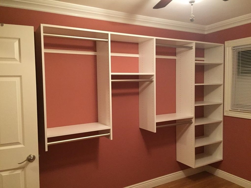 Photo of a medium sized modern gender neutral walk-in wardrobe in Other with flat-panel cabinets, white cabinets and light hardwood flooring.