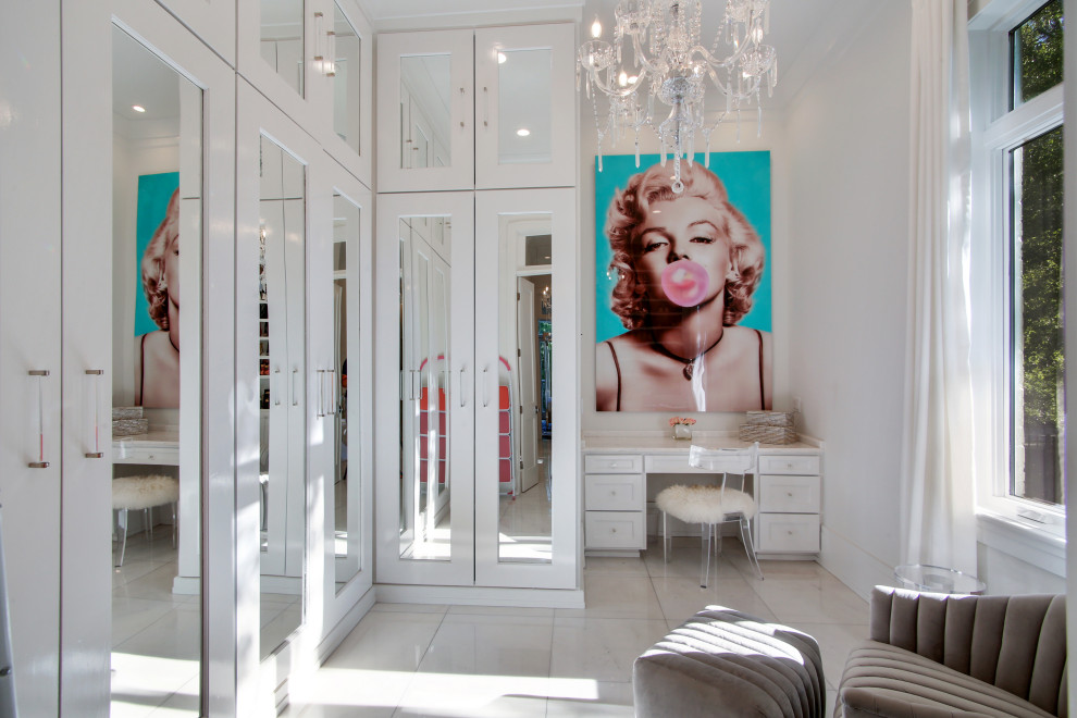 ニューオリンズにあるラグジュアリーな広いトランジショナルスタイルのおしゃれなフィッティングルーム (ガラス扉のキャビネット、白いキャビネット、大理石の床、白い床、三角天井) の写真