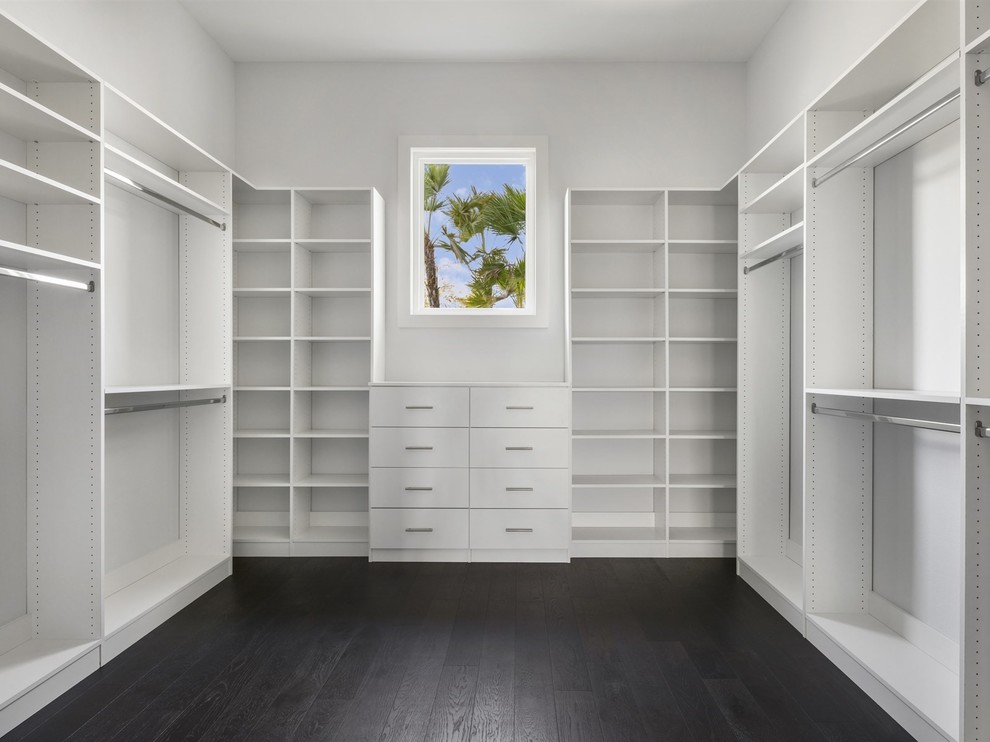 Example of a large transitional gender-neutral dark wood floor and brown floor walk-in closet design in Orlando with open cabinets and white cabinets