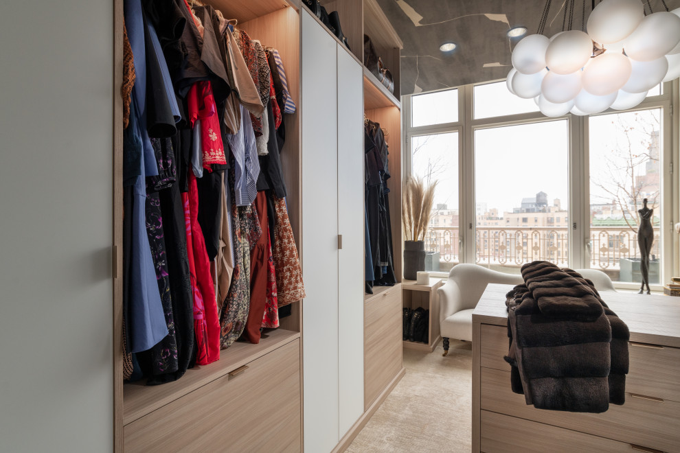 Imagen de armario vestidor de mujer moderno extra grande con armarios abiertos, puertas de armario beige, moqueta y suelo beige