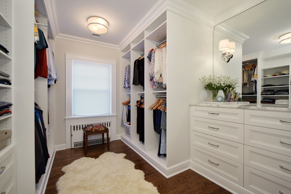 Large transitional gender-neutral medium tone wood floor and brown floor walk-in closet photo in New York with recessed-panel cabinets and white cabinets