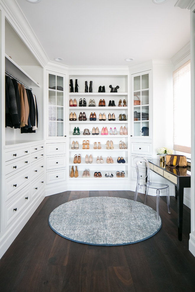 Photo of a large beach style walk-in wardrobe for women in Orange County with raised-panel cabinets, white cabinets, dark hardwood flooring and brown floors.