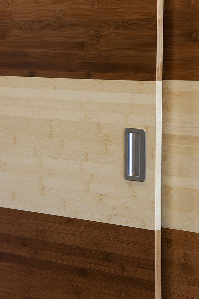 Photo of a large contemporary gender neutral standard wardrobe in San Francisco with flat-panel cabinets, medium wood cabinets and medium hardwood flooring.